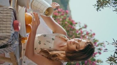 Romantik kadın terasa dikey su döküyor. Esmer kadın, Summer Mountain View 'da sakin bir hayat sürüyor. Nazik kadın model haftasonunu yalnız geçiriyor. 