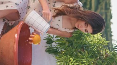 Terastaki meyvelerin üzerine meyve suyu döken nazik bir bayan. Romantik kadın portakalları kâsede yıkıyor yaz balkonunda tek başına oturuyor. Esmer sakin kız yeşillik doğasında öğle yemeği hazırlıyor.