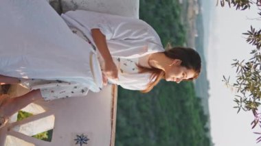 Dağ terasında dikey dikiş atan tatmin olmuş bir kadın. Esmer, rüzgarlı, uzun saçlı kadın. Yaz balkonunda tahta halkayla kumaşa iğne batırıyor. Rahat kız nakışla eğleniyor.