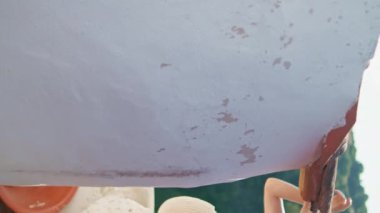 Dişi bayan Akdeniz gezisinin keyfini dikey olarak çıkarıyor. Rüzgarlı beyaz elbiseli romantik kadın eski sokakları keşfeden kırmızı fayanslara dokunuyor. Sakin ve narin görünümlü menekşe çiçekleri yaz günü çalılıklarda yürüyor.