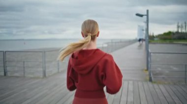 Sabahları şehir körfezinde koşan bir atlet. Spor kıyafetleri içinde spor koşusu yapan aktif bir kız. Nehir kenarındaki kardiyo çalışmalarına dayanıklılık eğitimi veren tanınmamış bir kadın koşucu..