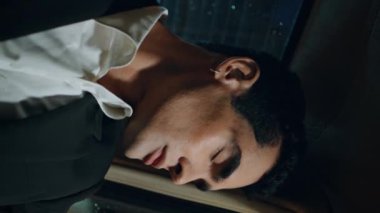 Rahat uyuyan yolcu aracı iş seyahatleri yakın mesafede. Gözler kapalı işadamı hareketli arabanın dikey videosunda yağmurlu pencereye yaslanıyor. Resmi kıyafetli uykulu adam arka koltukta uzanmış tek başına kestiriyor..
