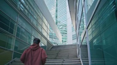 Cam binalar arasında şehir merdivenlerinde koşan bir adam. Şehirde formda koşucu eğitimi. Tanımlanamayan sporcu sabahları şehri keşfediyor. Etkin ve enerjik sporcu modern mimariye doğru koşuyor..