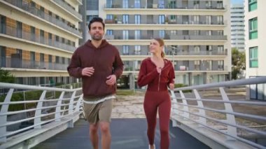 Şehir caddesinde birlikte koşan bir çift. Spor yaparken spor kıyafetleriyle koşan aktif bir kadın. Şehir sporcuları güneşli sabahlarda kardiyo eğitiminin keyfini çıkarıyorlar. Şehirde çok kültürlü sporcular var..