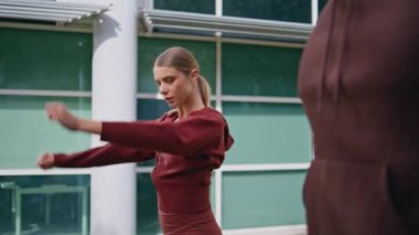 Kapalı alan aktif insanlar dışarıda çalışıyor. Fit bir kız tanınmayan bir erkek koçla fitness antrenmanı yapıyor. Kollarını esneterek pilates yapan odaklanmış güzel bir sporcu. Sportif kadın koşuya hazırlanıyor.