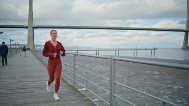 Deniz kıyısında iskele işleten zinde bir kız. Kardiyo koşusundan sonra ara veren yorgun bir sporcu. Sahil boyunca spor giyim eğitiminde aktif bir kadın. Genç sporcu bayan koşudan sonra geriliyor..