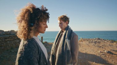 Üzgün çift okyanus kayalıklarını birbirine yaklaştırıyor. Kıvırcık kadın sarışın adam rüzgarlı deniz kıyısında birbirini görmezden geldiği için üzgün hissediyor. Çeşitli çiftler ayakta