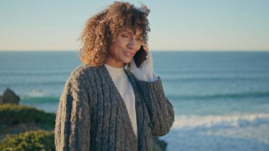 Turist kız, Ocean Beach 'te cep telefonuyla arıyor. Mutlu gülümseyen Afrikalı Amerikalı kadın hafta sonu tatilinde akıllı telefondan arıyor. Neşeli kaygısız bayan Tepede pozitif sohbet 