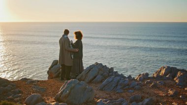 Huzurlu bir çift deniz kıyısında gün batımını seyrediyor. Okyanus manzarasında birbirlerine sarılmış romantik eşlere bakıyorlar. Terk edilmiş bir yerde yeni evlilerin yıl dönümünü kutlamak.