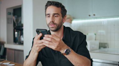 Hipster cep telefonuyla sesli mesaj kaydediyor. Oturma masası rahat kafeteryasını kapatın. Hoparlörde konuşan çekici bir adam arkadaşlarını arıyor. Sakallı adam akıllı telefon uygulaması kullanarak sesli mesaj konuşuyor..