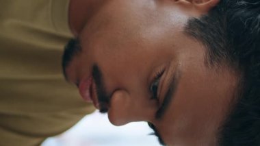 Latin Amerikalı erkek portresi kafeteryada tek başına oturuyor. Bıyıklı çekici Brezilyalı adam, akıllı telefon çekimine tepeden bakıyor. Modayı takip eden yakışıklı kafe dikey olarak mesaj okuyor..