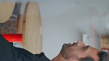 Birkaç erkek arkadaş pencerenin arkasında, rahat kafe manzarasında buluşuyor. İki etnik çeşitlilikte adam, dostça bir toplantıda gülüşerek konuşuyor. Kahvehanede şakalaşan neşeli adamlar dikey videoda konuşuyor.