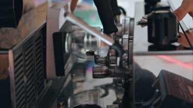 Barista elleri kafeteryada modern kahve makinesiyle kahve yapıyor. Profesyonel ekipmanlarda kafein hazırlama içeceği. Bilinmeyen kafe işçisi dikey olarak nefis espresso yapıyor..