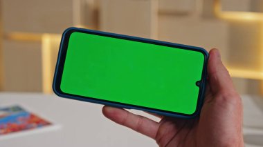 İş yerindeki Chroma Key cep telefonunda Freelancer tarama uygulaması. Yeşil ekran akıllı telefondan video içeriği izleyen tanınmayan bir menajer. Ceo iş e- postalarını cep telefonunda okuyor.