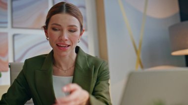 Yaratıcı ajansta video konferansı yapan neşeli bir kadın. Mutlu gülümseyen menajer, online görüşme yapan partnerlerle sonuçları tartışıyor. Arkadaş canlısı, güzel bir çalışan arıyor.