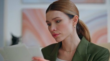 Patronun evrak okuduğu masa başı işyerindeki ofis içi yakın plan çekimleri. Odaklanmış bir yönetici ödevlerle çalışıyor. Yoğunlaşmış hissediyor. Sadece grafiklerle ilgili bilgileri karşılaştıran dikkatli bir kadın.