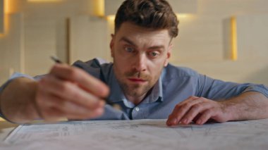 Müteahhit, mühendislik şirketinin yakın plan mimari projesini çiziyor. Ofis masasının planlarını yapmaya odaklanmış bir mimar. Stüdyoda inşaat tasarısı analiz eden bir adam.