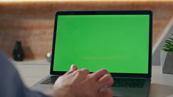 Stock image Man hands swiping chromakey laptop at morning office table closeup. Unknown creator working at mockup computer on remote job indoors. Unrecognizable developer browsing internet on pc with green screen