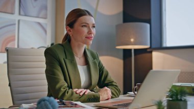 İnternetteki danışman dinlenme ofisin kutlu olsun. Gülümseyen neşeli kadın iş yerinde rahatlıyor ve ajans kabinesinde fikirler yaratıyor. Tatmin olmuş bayan rahat bir oda sandalyesinde mesai molası veriyor.