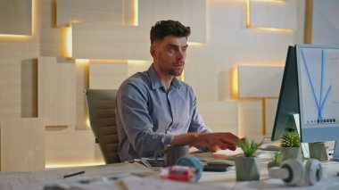 Ofis müdürü yaratıcı ofiste klavyeyi daktilo ediyor. İş yerindeki projede çalışan ciddi yakışıklı bir çalışan. Odaklanmış iş adamı olarak iş stratejisi oluşturmaya başlamayı düşünüyorum