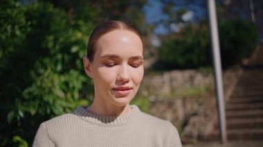 Güneş ışığına yakın park eden rahat model. Şehre gülümseyen genç bir kadın sıcak havanın tadını çıkarıyor. Yaz güneşinde ısınan sevimli narin kız bahçede gözlerini kapatıyor. Halk yaşam tarzı konsepti