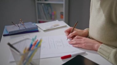 Bilinmeyen öğretmen, ofis masasında not alarak ev ödevlerini kontrol ediyor. Elleri kalem tutan genç bir kadın testlere işaretler koyuyor. Okulda tek başına çalışan tanınmamış bir eğitimci. Görev konsepti