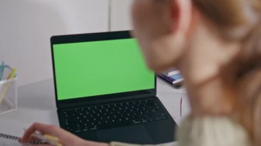 Öğretmen ev ödevi kromakey laptop iş yerini kontrol ediyor. Yakın plan. Tanımlanamayan bir kadın okul ofisinde yeşil ekran bilgisayara bakıyor. Sınıfta bilinmeyen profesör bayan dijital cihazla çalışıyor.