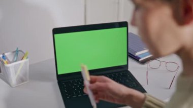 Özel ders notları kontrol ediyor. Dizüstü bilgisayarın yeri, yakın çekim. Tanımlanamayan bir kadın okul ofisinde yeşil ekran bilgisayara bakıyor. Sınıfta krom anahtarlı dijital cihazla çalışan bilinmeyen profesör bayan.