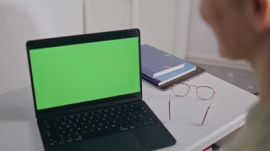 Bilinmeyen iş kadını video konferansında ofis kapanışı için laptop kullanıyor. Tanımlanamayan genç bayan yönetici web kamerası yeşil ekran bilgisayarında konuşuyor. Kromakey ekran ile çalışan kız