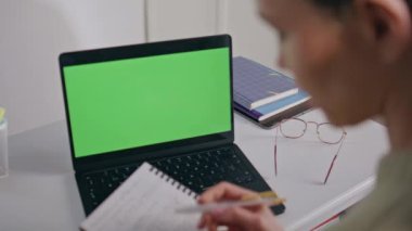 Eğitimci kadın, evdeki bilgisayarı kullanarak görüntülü arama yapıyor. Chromakey laptop işyerinde internette konuşan tanınmayan bayan öğretmen. Öğretmen sınıfta sanal konferans yapıyor.