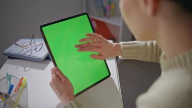 Mockup tabletindeki kadın, sosyal medyaya göz gezdirirken ev ofisini kapatıyor. Modern işyerinde çalışan yeşil ekran bilgisayarı tutan özel hocalar. Krom anahtar aygıtı kullanan bilinmeyen öğretmen 