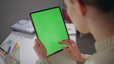 Öğrenci kız iş yerinde internet sörfü için kromakey tableti kullanıyor. Ofiste elinde yeşil ekran bilgisayar tutan kadın elleri dokunmatik ekrana dokunuyor. Bilinmeyen bayan tek başına çalışıyor.
