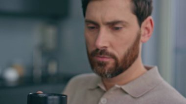 Rahat iş adamı akıllı telefon görünümlü, sabah yakın planda mesaj okuyor. Sakin sakallı, serbest çalışan, çay içen, sosyal medya telefonlarını izleyen bir adam. Ciddi bir adam cep telefonundan haberlere bakıyor.