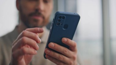 Sakallı menajer sabahları cep telefonu kullanıyor. Gülümseyen işadamı, lüks bir dairede oturup gülümseyerek mesaj okuyor. İnsan elleri cep telefonu ekranını yazarak sosyal medyayı tarıyor