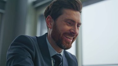 Şehir manzarası ofisinde oturan, evrak işleriyle uğraşan mutlu adam. Rahat CEO, çağdaş kabinedeki mesafesinin tadını çıkarıyor. Gülümseyen müdür belgeleri okurken kendini yalnız hissediyor