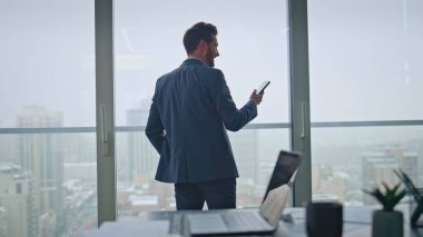 İşletme müdürü cep telefonuyla konuşuyor. Panoramik pencere lüks ofis manzarasına bakıyor. Kendine güveni tam bir iş adamı iş görüşmelerini uzaktan çözer. Yakışıklı girişimci akıllı telefon konuşmasını bitiriyor.