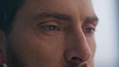 Çatık kaşlı adam gözleri açık daireye yakın mesafeye bakıyor. Ciddi bir adamın yüzü e-kitap okurken sıcacık bir evde rahatlıyor. Orta yaşlı esmer manken evde sakin bir hafta sonu geçiriyor.