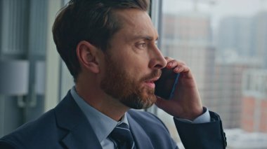 Kapanışta ciddi bir adam panoramik pencerede akıllı telefon çözme problemini arıyor. Yönetici, iş görüşmesi için ortakla görüşüyor. Orta yaşlı işadamı ofiste duran anlaşmayı tartışıyor