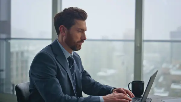 stock image Man manager corresponding client using laptop at luxury office closeup. Busy serious businessman focused on computer work. Handsome bearded guy entrepreneur holding pen taking notes at workplace 