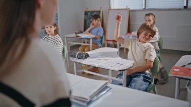 Akıllı çocuklar derste el kaldırıyor. Tanımlanamayan öğretmen, öğrencilerin sınıf odasında eğitim sürecinin tadını çıkardığını söylüyor. Eğitimci, ilkokuldaki çeşitli çocuklara açıklama yapıyor. Erkek kızlar okula gidiyor.