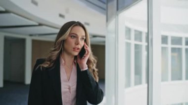 Şirket profesyoneli akıllı telefonu arıyor modern ofis koridorunda yürüyor. Çekici başarılı iş kadını problem projesini tartışıyor. Şirkette çalışan şık bir kadın yönetici konuşması.