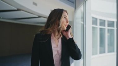 Başarılı bir yönetici cep telefonuyla konuşuyor. Kapanış yöneticisi ofis kontrol saatinde toplantıya gidiyor. Akıllı telefondan iletişim kuran ciddi bir profesyonel yönetici. Dalgın kadın patron yürüyen cam koridor.