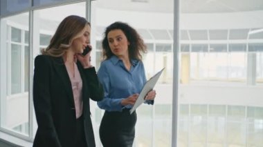 İş arkadaşları belgeyi tartışıyor. Gülümseyen kadın projede yönetici danışmanlığına yardım ediyor. Kendine güvenen bir iş kadını cep telefonlu ofis koridorunda konuşuyor. Kurumsal insanlar yakın çekim