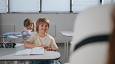 Anaokulu çocuğu ders çalışıyor. Kitaplar yazan küçük okul çocukları derste sınıf çalışması yapıyorlar. İlkokul çocuğu kabinede not almayı öğreniyor. Çocuk eğitimi konsepti 