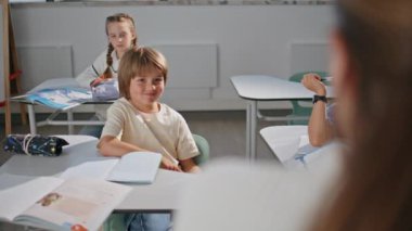 İlkokul çocuğu sınıf öğreniyor. Küçük okul çocukları derste ders kitapçığı yazıyorlar. Anaokulu öğrencisi kabinede notlar alıyor. Çocuk eğitimi konsepti 