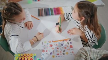 Çalışkan liseli kızlar okul sınıfında kalem çiziyorlar. Işık konferans salonunda konuşan güzel kızlar resim yapıyor. Sanat dersinden zevk alan iki öğrenci. Yaratıcılık kavramı