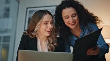 Profesyonel kadınlar modern ofiste projeleri tartışırlar. Yakın plan iş arkadaşları belgeleri işyerinde beşlik çakıyor. Yoğun bir akşamda kurumsal takım çalışması. Mutlu gülen işçiler başarıyı kutluyor