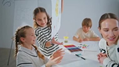 Yaratıcı çocuklar okulu kapatıyorlar. Komik küçük çocuklar resim dersinden zevk alıyorlar. Birlikte eğleniyorlar. Küçük oğlanlar resimleri inceliyor. Atölyeden memnun kalıyorlar. İlham verici yaratıcılık kavramı