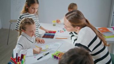 Öğrenci öğretmeni sanat okulunda resim hazırlıyor. Modern stüdyoda küçük kız ve kadın resimleri yapmaya odaklanmış. Yetenekli ressam kadın çocuklara resim atölyesinde ders veriyor. Yaratıcılık kavramı