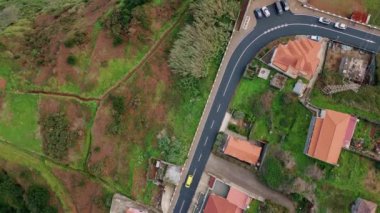 Samimi evler arasında uzanan köy yolu huzur verici bir manzara yaratıyor. Kırsal araziyi kaplayan yemyeşil bir arazi. Güzel caddelerde gezinen arabalar. Havadan çekilen kırmızı binaların çatıları